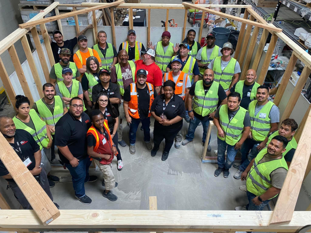 A large group of smiling students poses for a photo at a National Tile Contractors Association training event.
